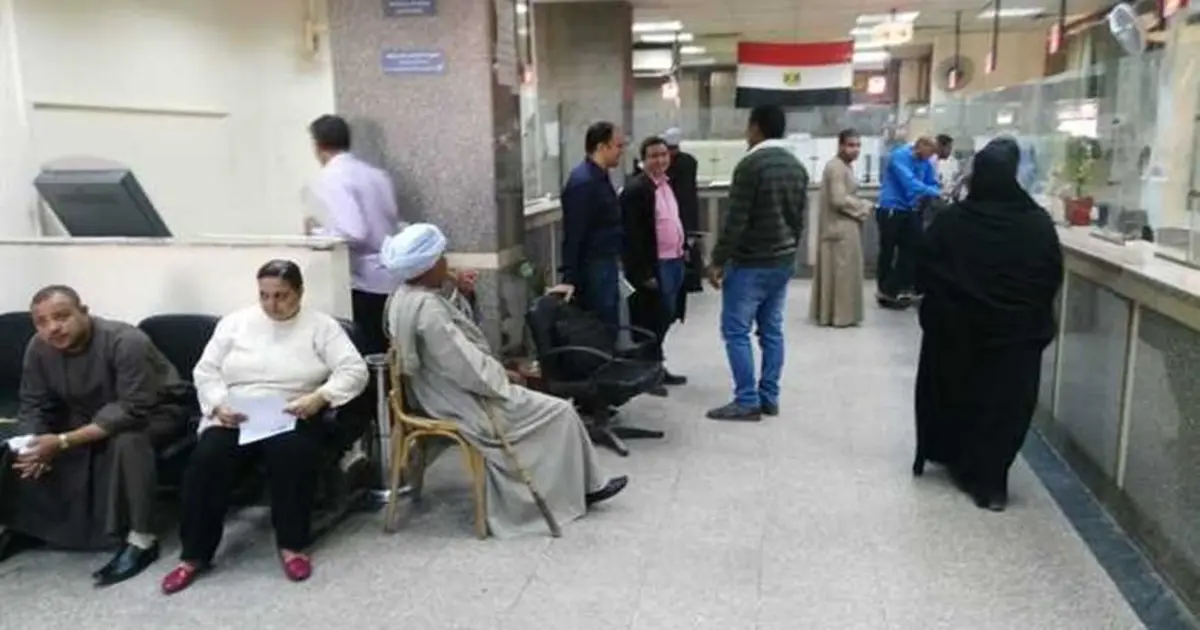 أشخاص داخل مكتب الشهر العقاري في مصر يستفسرون عن ماهي انواع التسجيل في الشهر العقاري وإجراءات التسجيل الرضائي والتسجيل القضائي والأوراق المطلوبة لتجنب رفض الطلب.