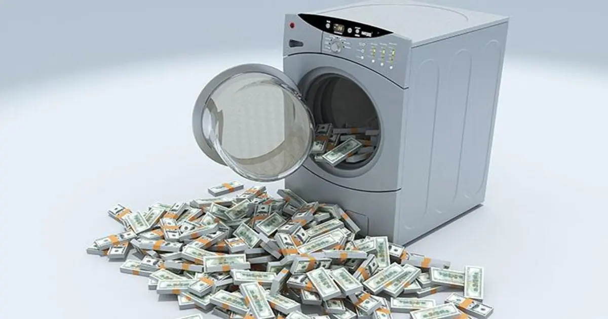 أحكام قضايا الأموال العامة غسالة تحتوي على دولارات وحولها مستندات وختم رسمي في دلالة على تتبع الأموال وإجراءات التحقيق في غسل الأموال.